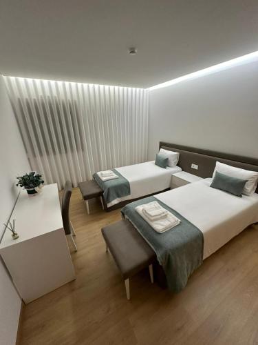 a hotel room with two beds and a table and chairs at Casa do Gaspar in Ribeira de Pena