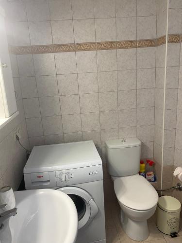 La salle de bains est pourvue de toilettes, d'un lavabo et d'un lave-linge. dans l'établissement Luxury Apartment 2, à Alexandroúpolis