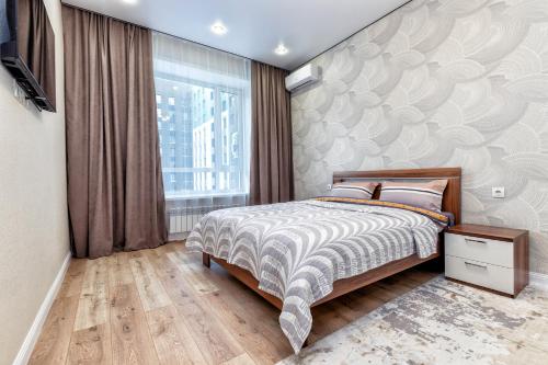 1 dormitorio con cama y ventana grande en Уютные апартаменты в центре левого берега, en Taldykolʼ