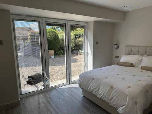 a bedroom with a bed and sliding glass doors at Beautiful 1-Bed Studio in Bourne end in Bourne End