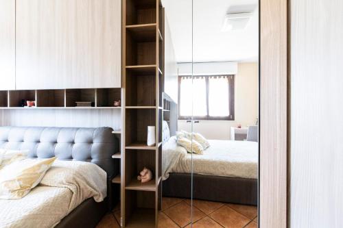 een slaapkamer met een spiegel naast 2 bedden bij Cooperazione 120 in Rozzano