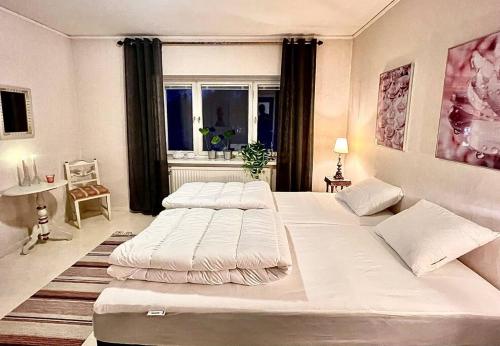 1 dormitorio con 2 camas y ventana en Centralt Skinnskatteberg 2 sovrum, en Skinnskatteberg
