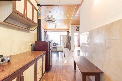 a kitchen with a table and a dining room at Kasauli Edge Apt with Balcony in Kasauli