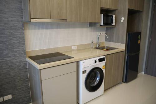 a kitchen with a washing machine and a sink at Circle Rein Sukhumvit 12 two bedrooms apartment in Khlong Toei
