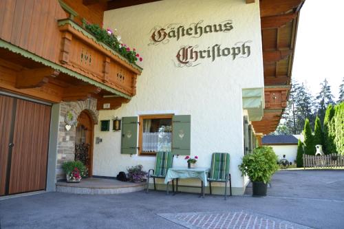 a building with two chairs and a table outside at Gästehaus Christoph in Ried im Zillertal