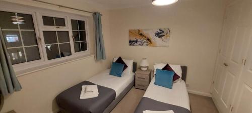 two twin beds in a room with a window at Charming 3 Bed house Family and Long-stay Discount in Maidenhead