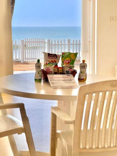 a white table with a view of the ocean at Beach at the White House in Udupi
