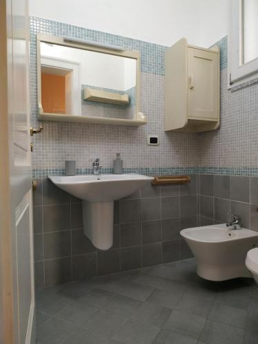 uma casa de banho com um lavatório, um espelho e um WC. em Ninanera em Casarano