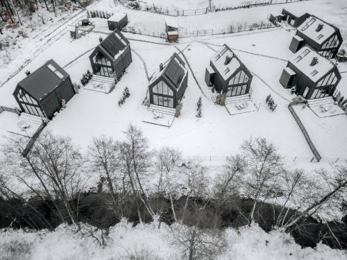 a group of houses covered in snow at Domki Momenty in Słajszewo
