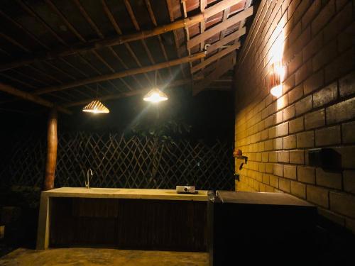 a room with a table and lights on a brick wall at Outskirts Of Heaven in Kamburugamuwa