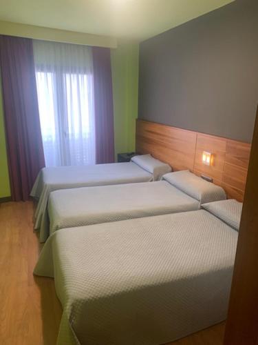 ein Hotelzimmer mit 2 Betten und einem Fenster in der Unterkunft Buenavista in Cuenca