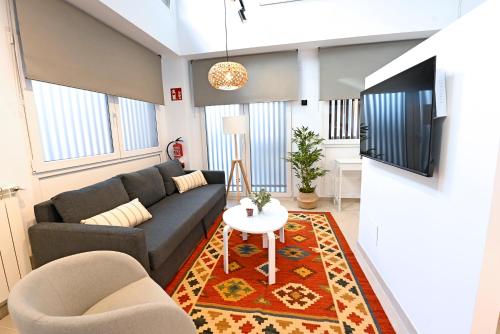 sala de estar con sofá y mesa en Apartamentos Bahía&Arena, en Santander