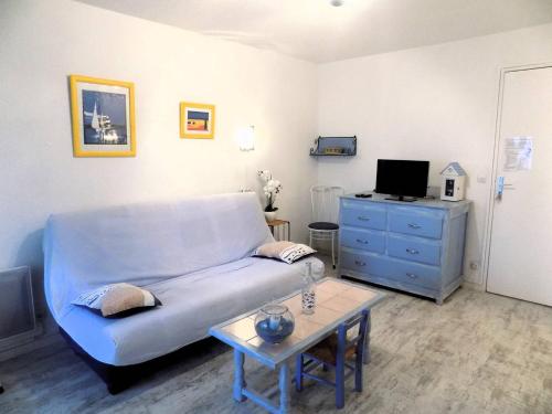 un salon avec un canapé bleu et une table dans l'établissement Saint Georges de Didonne - AGREABLE APPARTEMENT - PROCHE PLAGE - Evasion Marine, à Saint-Georges-de-Didonne