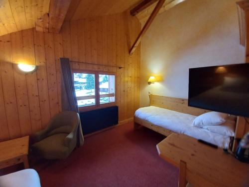 Habitación pequeña con cama y ventana en Chalet Hotel Le Mont Bisanne, en Crest-Voland