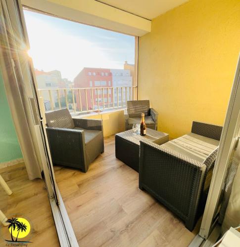 une chambre avec un balcon avec une table et des chaises dans l'établissement T4 Le Trente Cinq 3 chambres & climatisation, au Cap d'Agde