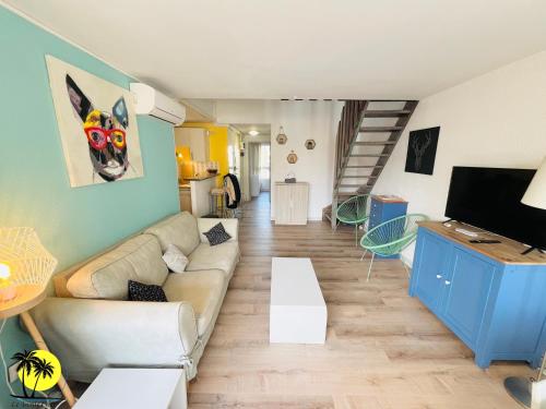 - un salon avec un canapé et une télévision dans l'établissement T4 Le Trente Cinq 3 chambres & climatisation, au Cap d'Agde
