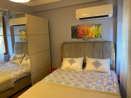 een kleine slaapkamer met 2 bedden en een spiegel bij 2+1 flat,In the center of Old Town in Antalya