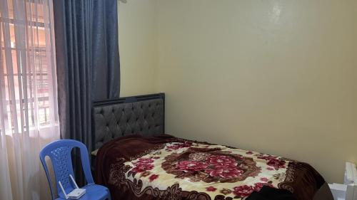 sypialnia z łóżkiem i kocem z kwiatami w obiekcie Chic Haven - Fully furnished 1 BR Gem w mieście Kiambu
