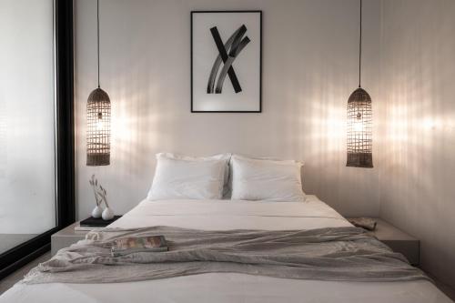 a bedroom with a bed and two pendant lights at HOOGA Feel The Cosiness & Mysa Restaurant , Preveza in Preveza