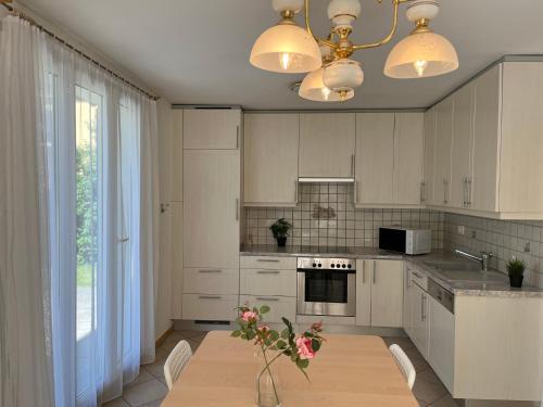 a kitchen with a table with a vase of flowers on it at Individual house free parking wifi Netflix Disney next to EPFL Lausanne in Ecublens