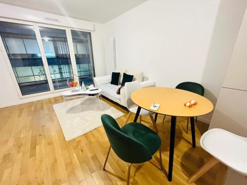 een woonkamer met een tafel en een bank bij Dream Dwell Paris-Fantastic modern flat near RER A Paris in Saint-Maur-des-Fossés