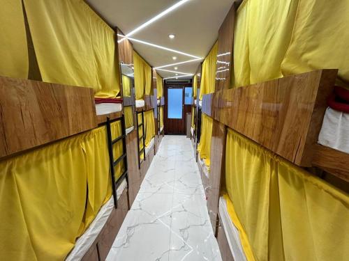 a corridor of a train with yellow walls at Sai Sharan Dormitory-Near Dadar Railway Station in Mumbai