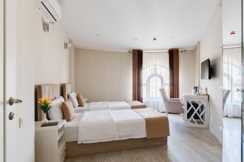 a white bedroom with a bed and a desk at Shoxjahon Hotel - 600 Mbps Internet in Tashkent