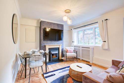 a living room with a table and a fireplace at Artsy Serviced Apartments - Highgate in London