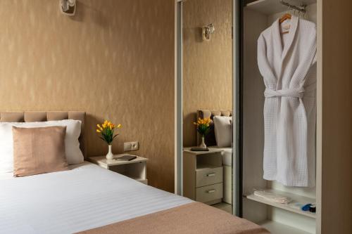 a bedroom with a bed and a robe hanging on a closet at Shoxjahon Hotel - 600 Mbps Internet in Tashkent