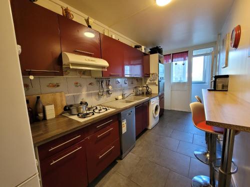 une cuisine avec des armoires marron et un comptoir dans l'établissement Charmante chambre chez l'habitant, à Ivry-sur-Seine