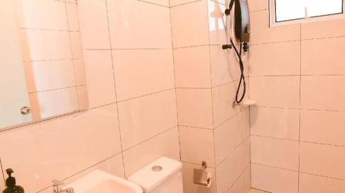 een badkamer met een douche, een toilet en een wastafel bij Amber Cove -Sunset Bliss Retreat Sea/CityView By Luxpro in Melaka
