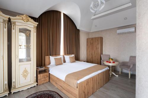 a bedroom with a bed and a table and a chair at Shoxjahon Hotel - 600 Mbps Internet in Tashkent