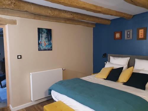 Le Terrier في Miserey-Salines: غرفة نوم بسرير مع جدار ازرق