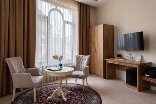 uma sala de estar com uma mesa e cadeiras e uma televisão em Shoxjahon Hotel - 600 Mbps Internet em Tashkent