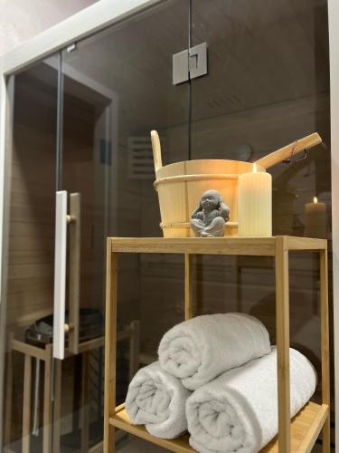 a shelf with towels and a basket and a mirror at Parkcity Katowice Bogucice in Katowice