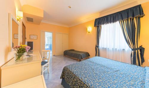 a hotel room with a blue bed and a window at Hotel Iaccarino in SantʼAgata sui Due Golfi