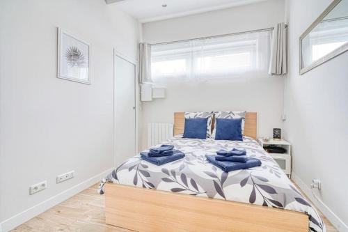 una camera da letto con un letto con cuscini blu di Studio cosy, Wifi, Netflix a Fleury-Mérogis