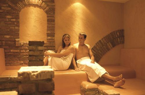 a man and a woman sitting on a mattress at Park Plaza Trier in Trier