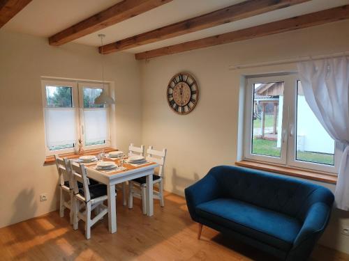 a dining room with a table and a blue couch at Zielony-Bursztyn in Objazda-Kolonia
