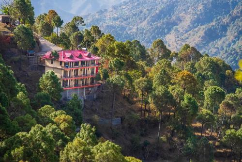 a building on a hill in the middle of a forest at Rudra Hotel And Resort ! New ! Mountain ! Kasauli in Kasauli