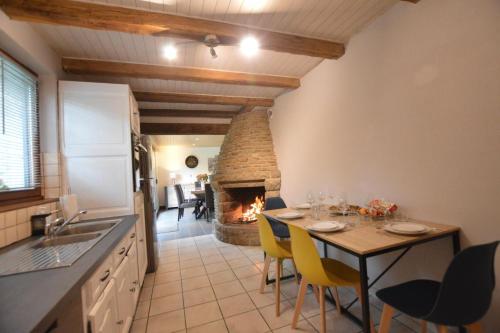Il comprend une cuisine et une salle à manger avec une table et une cheminée. dans l'établissement La hantelle, à Saint-Hilaire-des-Landes