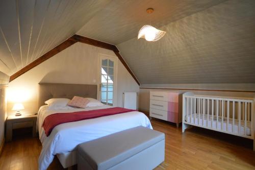 Saint-Hilaire-des-LandesにあるLa hantelleのベッドルーム1室(ベッド1台、ベビーベッド1台付)