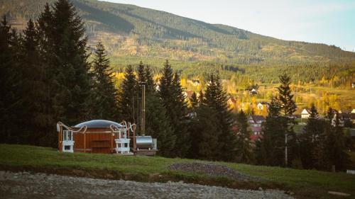 a building on a hill with trees in the background at Domek w górach balia Tiny House Polana Widokówka in Lipnica Wielka