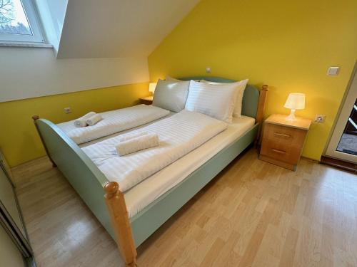 Apartment Izba Snovik في Laze v Tuhinju: سرير في غرفة بجدار اصفر