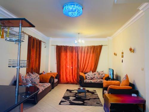 a living room with couches and a chandelier at فيلا دوبلكس في لاسيرينا السخنة in Ain Sokhna