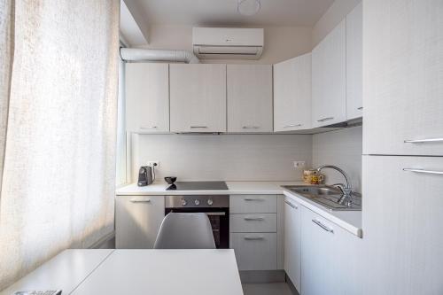 a small kitchen with white cabinets and a sink at Marchese 25 Apartments in Bari