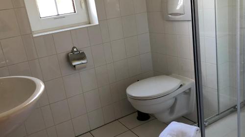 ein weißes Bad mit einem WC und einem Waschbecken in der Unterkunft -"Große Koje" Fewo im OG - Fischländer Weg 53A in Dierhagen