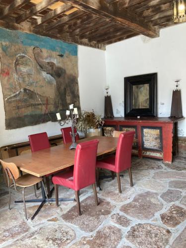 uma sala de jantar com uma mesa de madeira e cadeiras vermelhas em La Valuisilla, hotel rural em Cicera