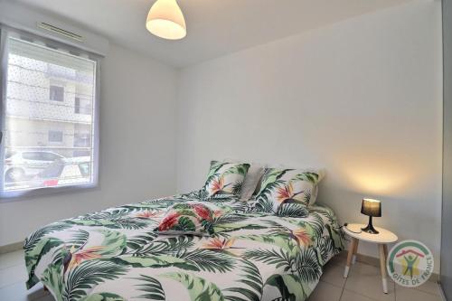 sala de estar con sofá con estampado tropical en Le balcon de sevigne, en Cesson-Sévigné