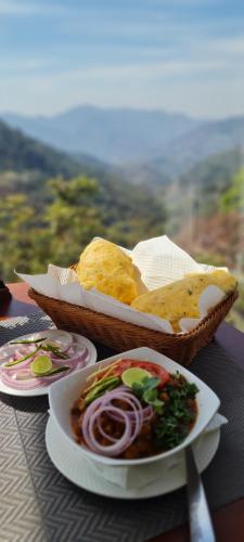 uma mesa com uma tigela de pão e um prato de comida em Oakhill Resorts em Solan